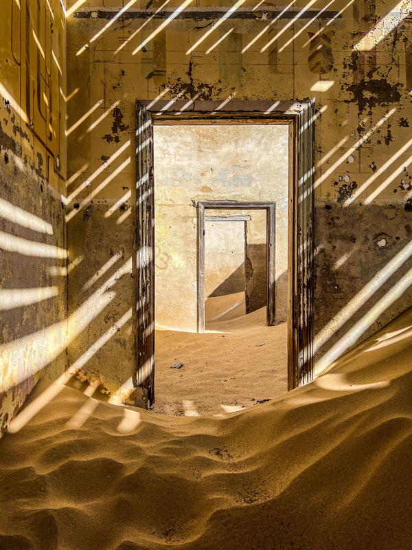 sand dunes entering the doors of an abandoned home in Kolmanskop, Namibia