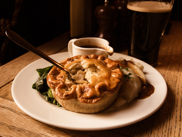 chicken pot pie on a plate with sauce on the side