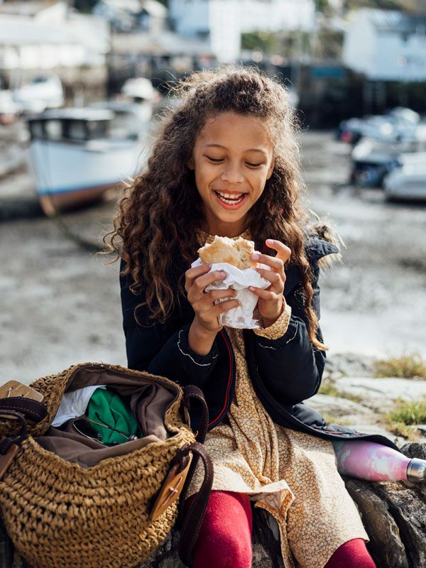 a little girl eating pasty in Polperro Village