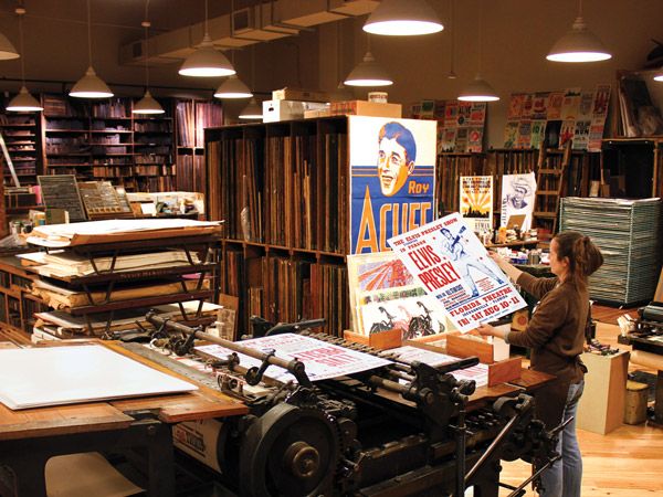 a woman inside the working letterpress print shop at Hatch Show Prints, Nashville