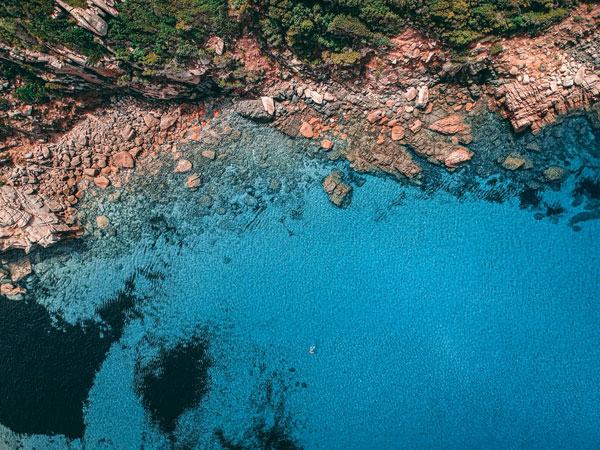 an aerial view of the waters and rocky coast on Tizzano Beach, Corsica
