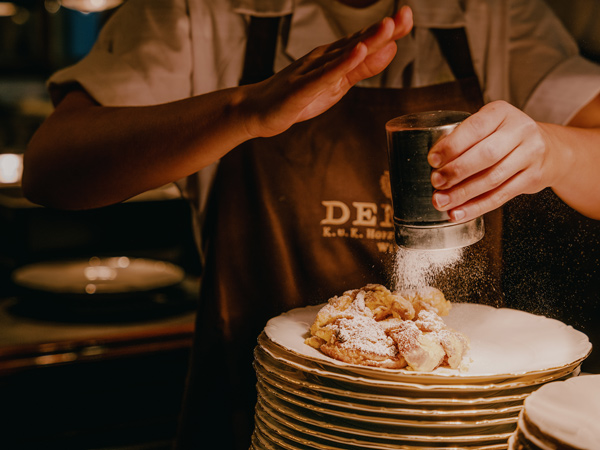 sprinkling powdered sugar on pastries at Demel coffee house