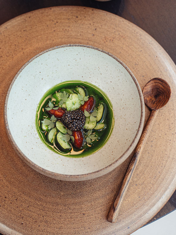 a dish with tomato, broad beans and caviar