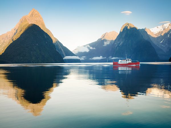 a boat at dawn in Milford Sound