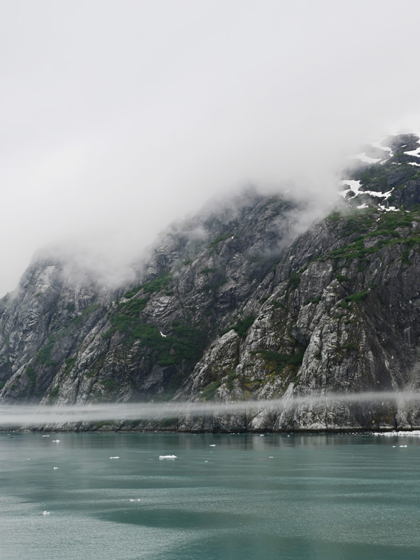 clouds cover the towering mountains in Glacier Bay