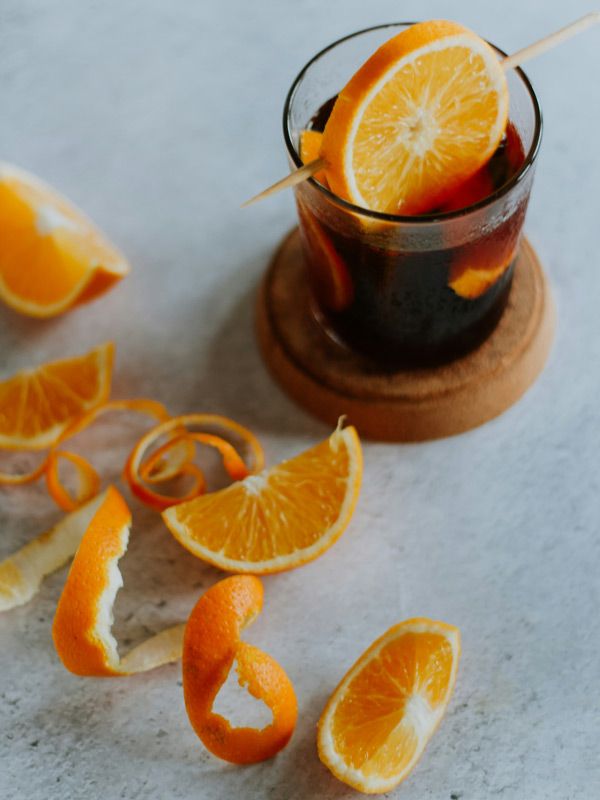 a glass of Vermouth with peeled oranges