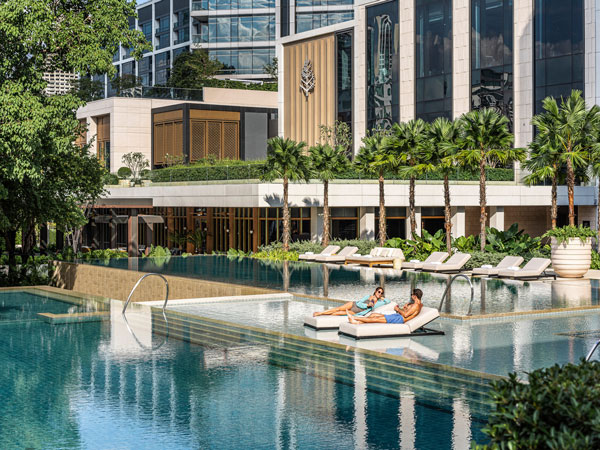 guests relaxing on sun loungers at the outdoor pool in Four Seasons Bangkok