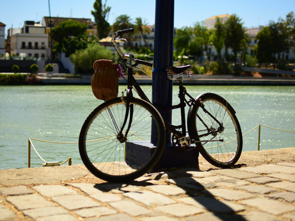 a bicycle parked on the side of a post in Seville, Spain