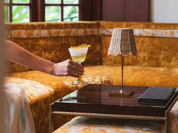 a hand holding a glass of cocktail at the lobby of The Brazilian Court Hotel, Palm Beach