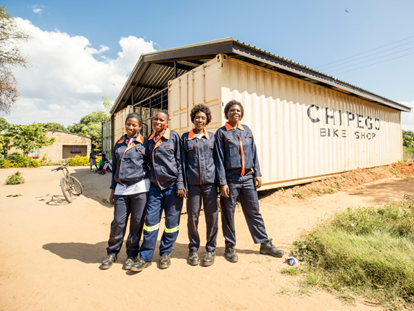 women at a bike shop in Uganda and Tanzania