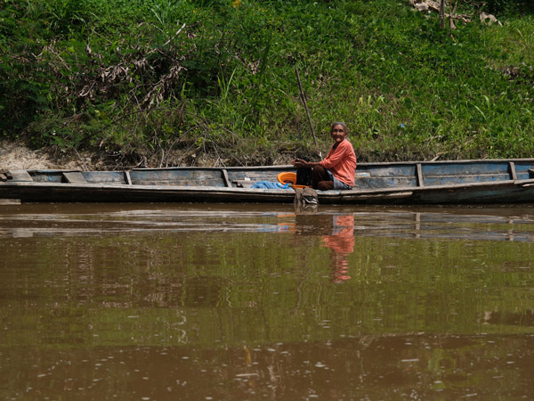 a local traversing the Amazon River on a traditional dugoutcanoe