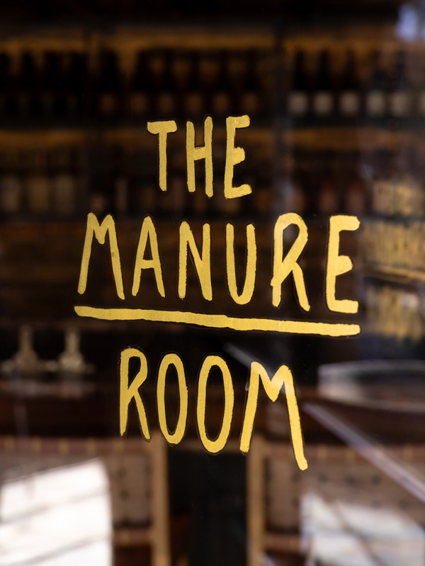The Manure Room signage on the glass