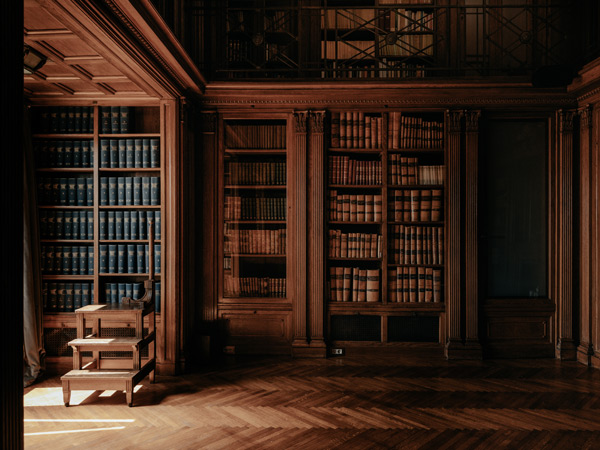 floor-to-ceiling bookshelves inside the library at Grand Hotel Central Barcelona