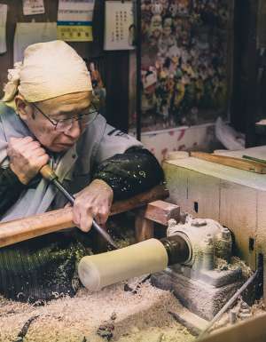 An artisan making a kokeshi doll