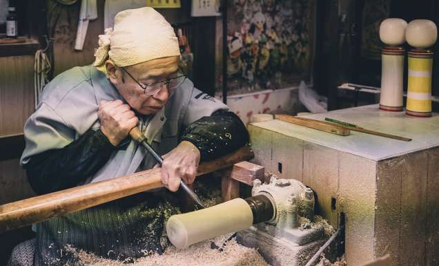 An artisan making a kokeshi doll