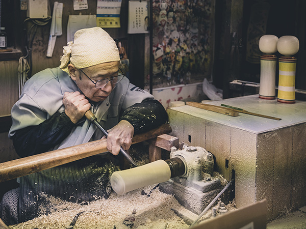 An artisan creating a kokeshi doll