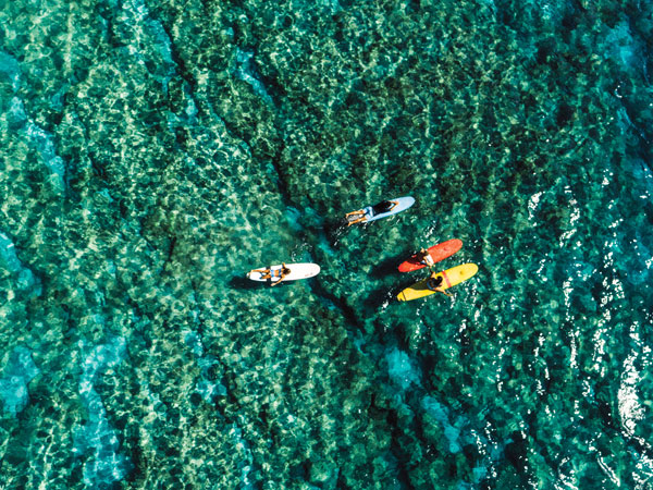 an aerial view of surfers in Hawai'i