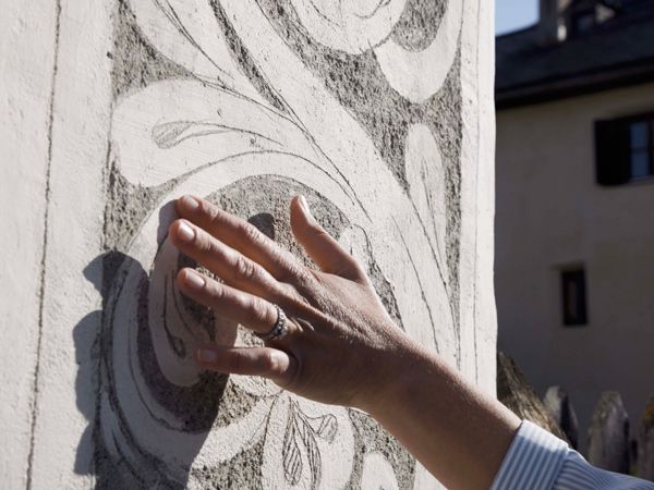 a hand touching the facades on a Sgraffito tour with Pauline Martinet
