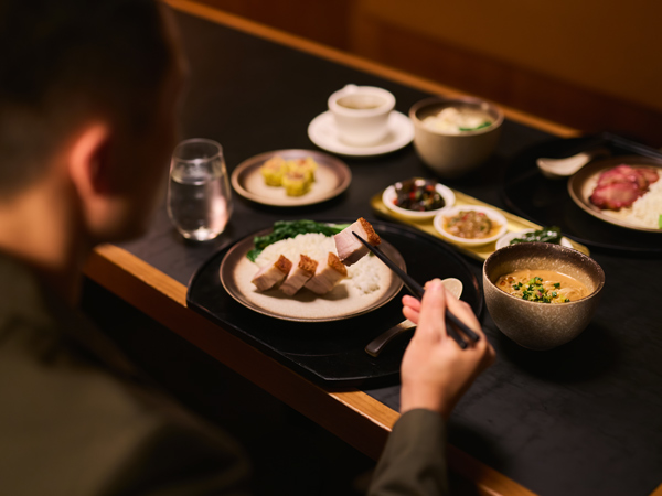 a man eating at The Pier, Cathay Pacific Business lounge