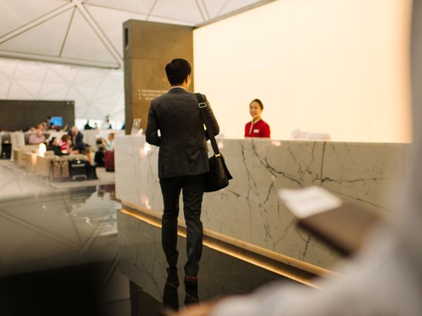 a passenger arriving at the reception area of The Wing, Cathay Pacific Business lounge