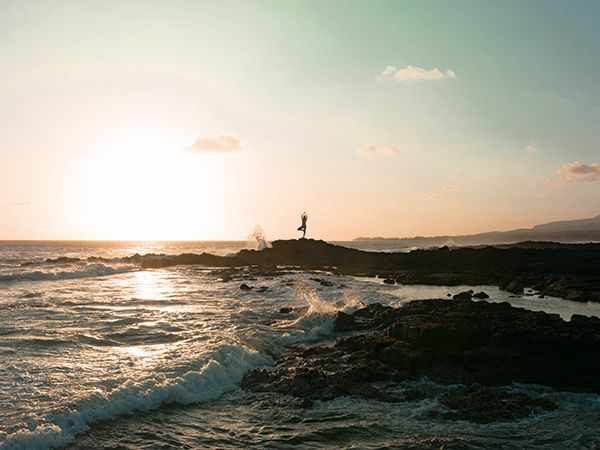 A person doing yoga in the beach