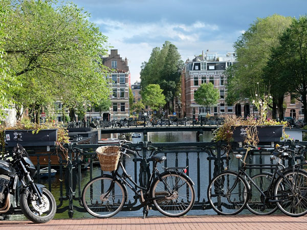 bicycles parked on the side of a canal in Amsterdam