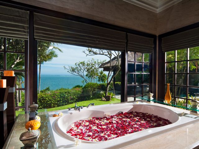 a bathtub with petals at AYANA Bali