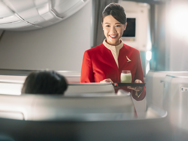 a Cathay Pacific crew holding a drink