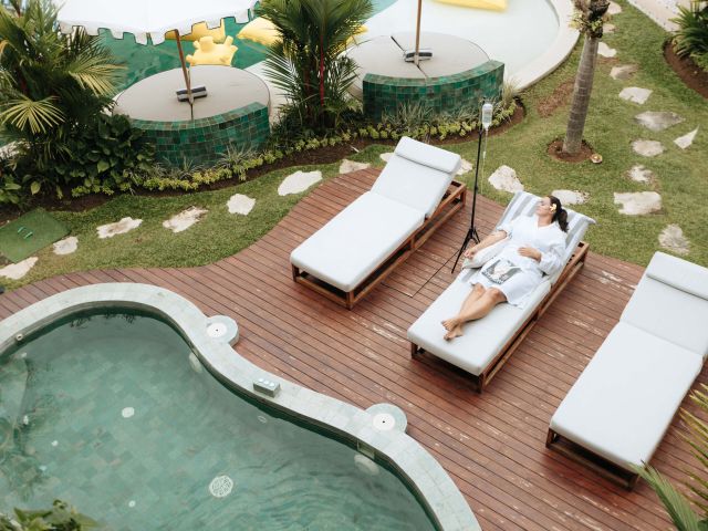 a woman relaxing by the pool at Escape Haven, Canggu