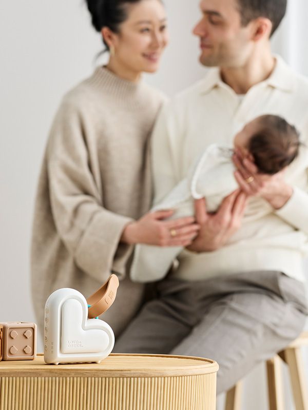 A young family holding their new baby with the Love to dream sleep machine