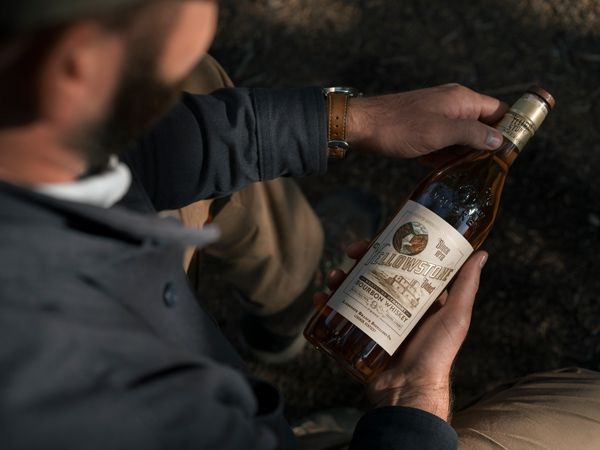 A man holding the Yellowstone Select Kentucky Straight Bourbon Whiskey.