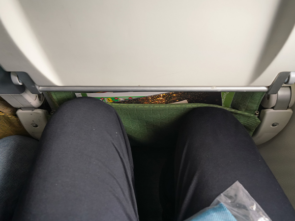 tall person trying to fit into a plane seat