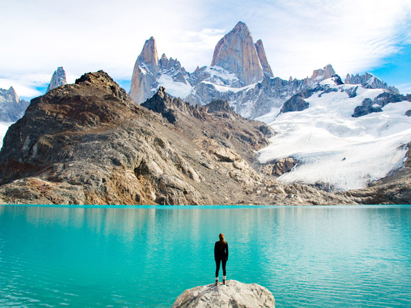 a man standing on the edge of a rock admiring the Chilean Patagonia