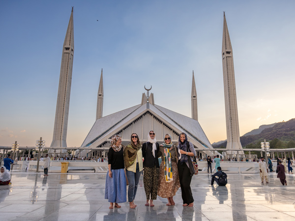 a group of travellers posing in front Islamabad’s Faisal Mosque