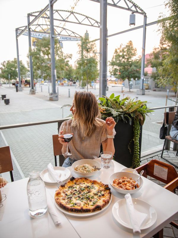 a woman dining pizza at The Shipyards