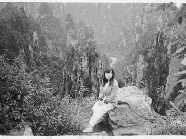 Wendy Wu sitting on a rock