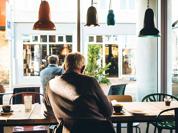old man with coffee in cafe