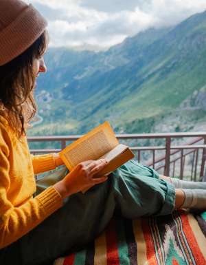 woman reading in van on top of the swiss alps