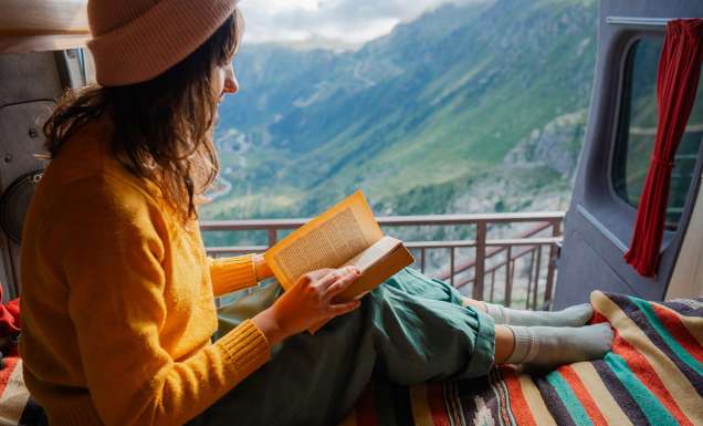 woman reading in van on top of the swiss alps