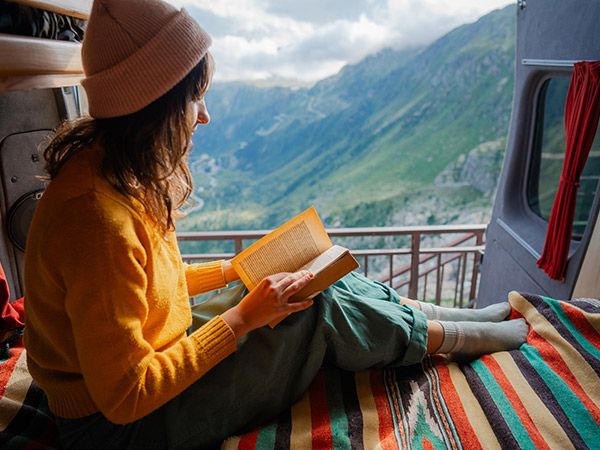 woman reading in van on top of the swiss alps