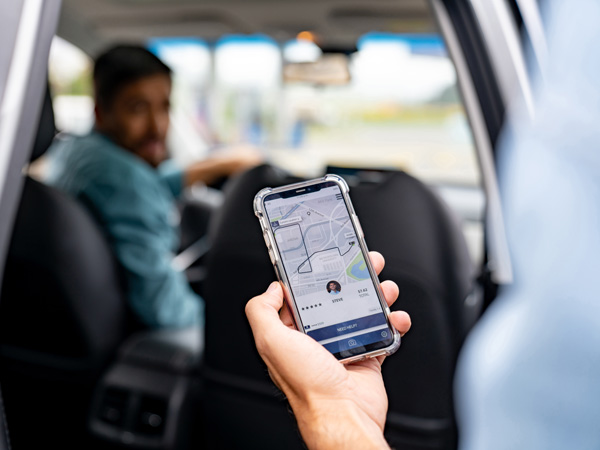 A person holding a phone in front of an Uber