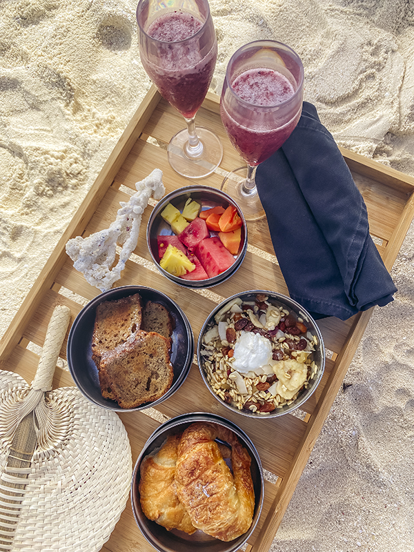 A tray filled with food and glasses of wine.