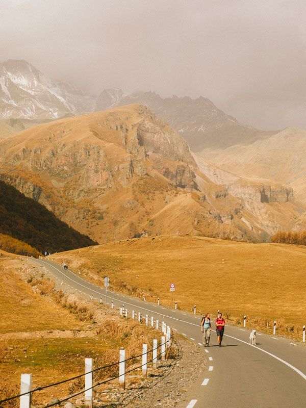 tourists walking backdropped against the Caucasus-Mountains in Georgia