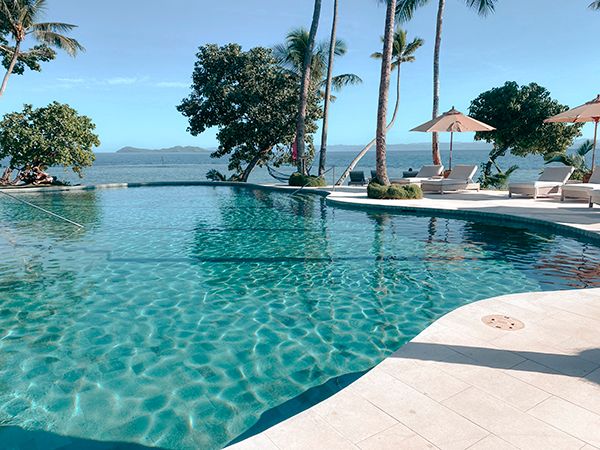 A serene pool stretches invitingly toward the horizon, with the turquoise waters.