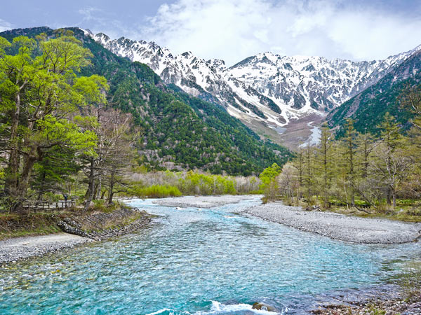 Azusa River flowing in front of landscape view of Mount Hotaka-Dake on blue sky day in Kamikochi, Nagano, Japan.