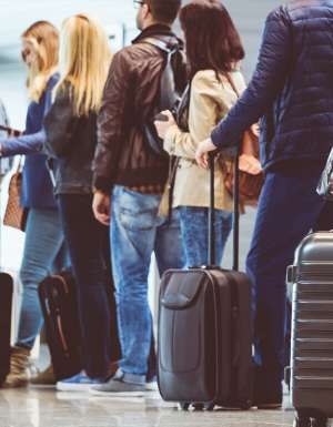 People lining up with carry-on baggage to board a flight