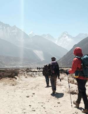 group tour hiking towards himalayan mountain ranges