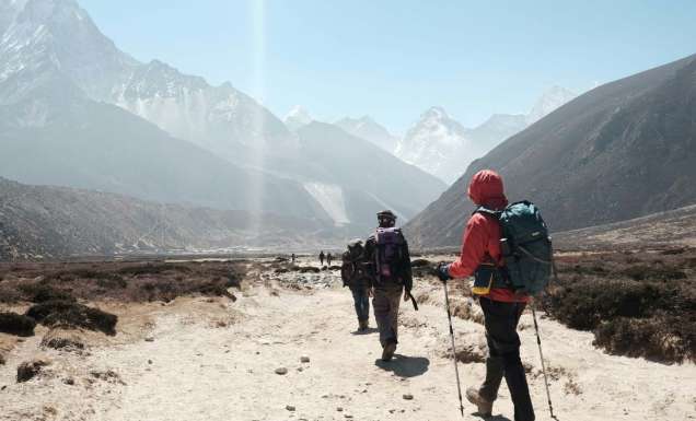 group tour hiking towards himalayan mountain ranges