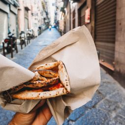 Point of view of a man eating a typical "Pizza a portafoglio" in Naples, Italy