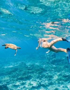 Woman explores the reef around the atoll in the Maldives